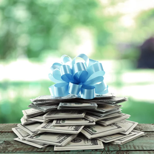 Stapel dollars met boog als geschenk — Stockfoto
