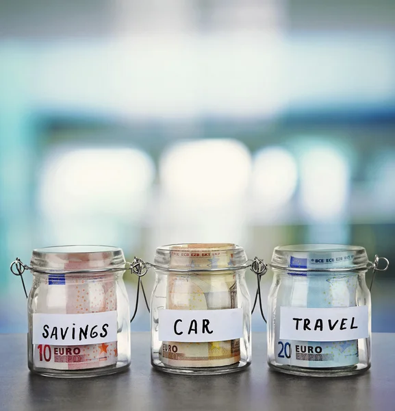 Jars for different needs full of banknotes — Stock Photo, Image