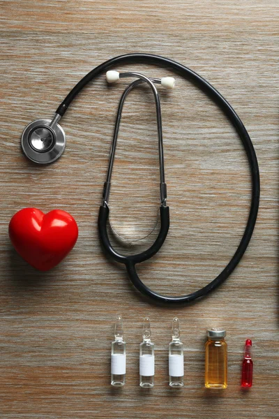 Mesa médica com medicamentos e estetoscópio — Fotografia de Stock