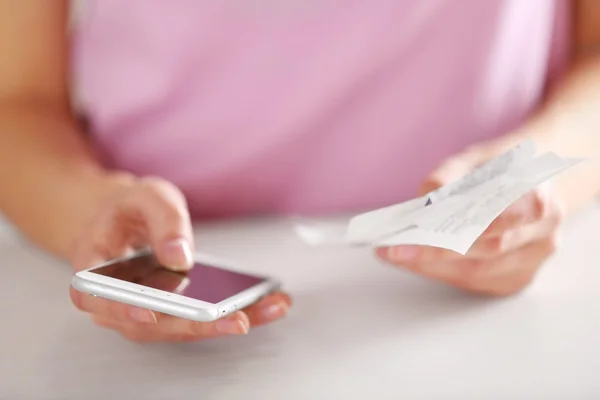 Woman with bills and smart phone — Stock Photo, Image