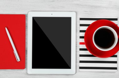 Dijital tablet fincan kahve ve ahşap masa, closeup üstünde defter ile
