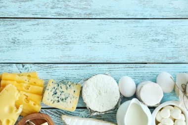 Çerçeve mavi ahşap masa üzerinde taze süt ürünleri