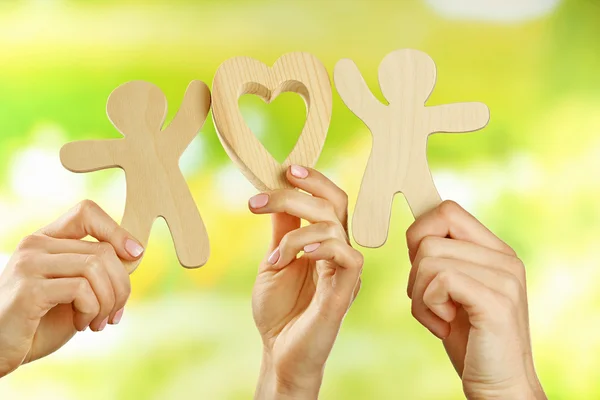 Hands holding a couple of wooden figures — Stock Photo, Image