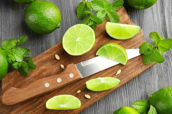 Fresh limes on cutting board — Stock Photo, Image