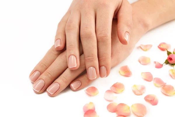Vrouw handen met rozenblaadjes — Stockfoto