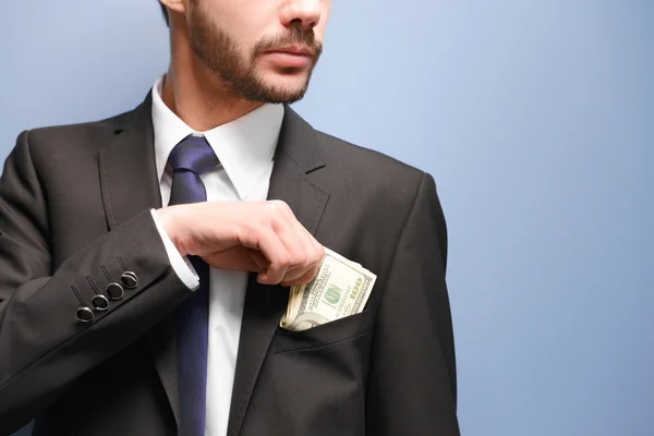 Man in a suit holding dollar banknotes — Stock Photo, Image