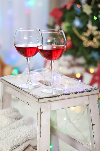 Dos copas de vino tinto sobre fondo de decoración navideña — Foto de Stock