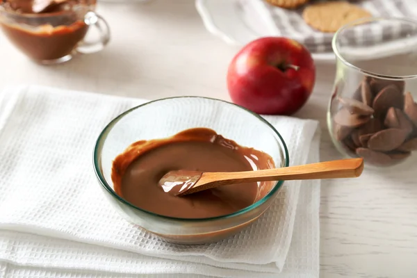 Chocolate derretido en un tazón de vidrio, sobre fondo de madera — Foto de Stock