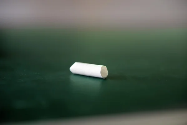 Piece of white chalk on blackboard — Stock Photo, Image