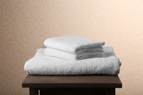 White towels on brown chair over beige background — Stock Photo, Image