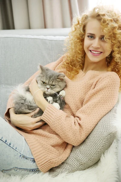 Jeune femme et chat sur le canapé dans la chambre — Photo