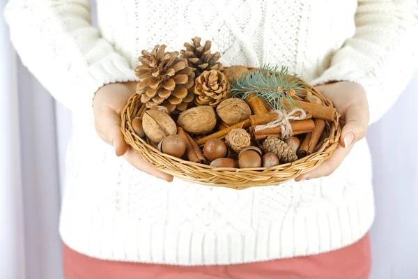 Cesta de vime com decoração de Natal em mãos de mulher, close-up — Fotografia de Stock