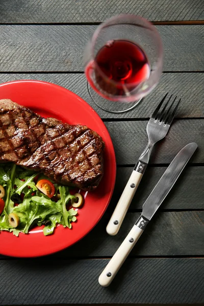 Gegrilde steak met plantaardige salade en glas wijn, close-up — Stockfoto