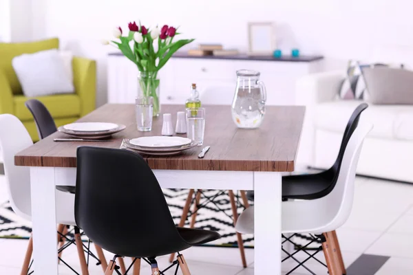 Modernes Wohnzimmer. Möbel mit Tisch und Stühlen. Strauß schöner lila Tulpen auf dem Tisch — Stockfoto