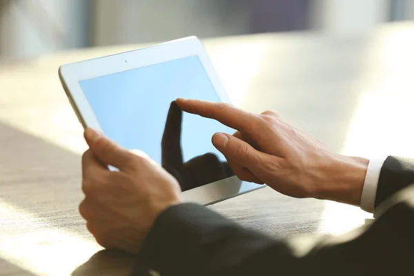 Iemands hand met behulp van de tablet aan de tafel in office — Stockfoto