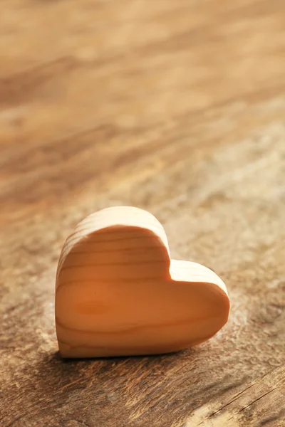 Corazón de madera sobre fondo rústico de madera — Foto de Stock