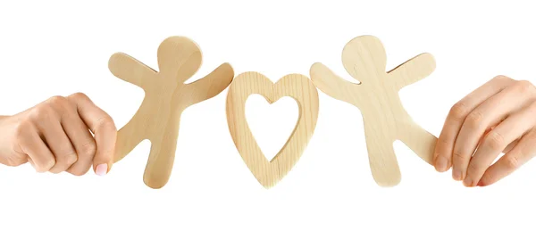 Mani che tengono un paio di figure di legno con cuore, isolate su bianco — Foto Stock