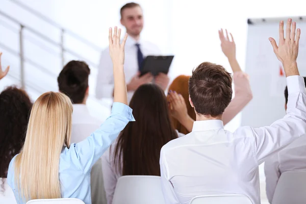 Colegas levantando as mãos na reunião de negócios — Fotografia de Stock