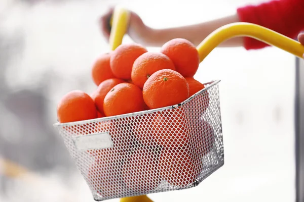 Kvinnan kör cykel med mandariner — Stockfoto