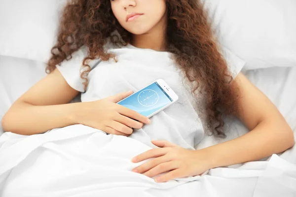 Menina na cama com celular — Fotografia de Stock