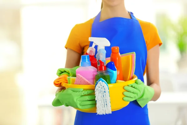 Mujer con guantes sosteniendo lavabo con detergentes — Foto de Stock