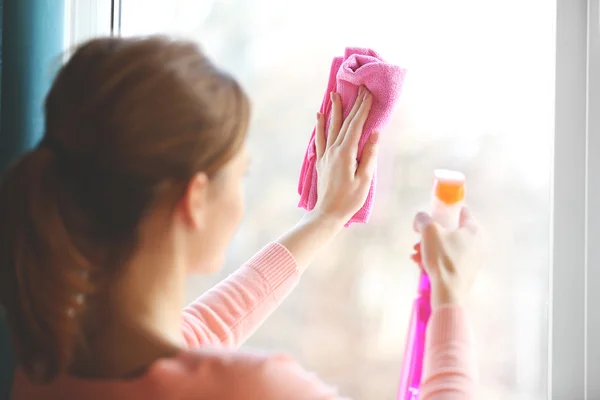 Ung kvinna tvätta fönster — Stockfoto