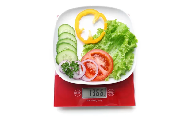Teller mit geschnittenem frischem Gemüse auf digitaler Küchenwaage, isoliert auf weiß — Stockfoto