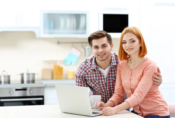 Casal usando laptop na cozinha — Fotografia de Stock