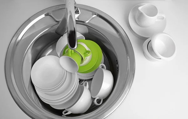 Pile of dishes in sink — Stock Photo, Image