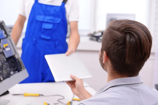 Jeune Homme Donnant Ordinateur Portable Cassé Réparateur Dans Centre Service — Photo