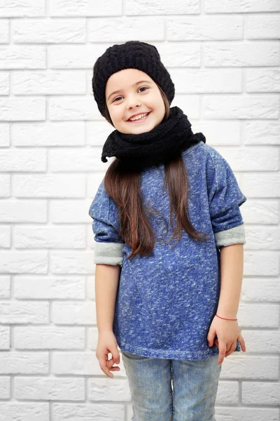 Little girl on a white brick wall background — Stock Photo, Image