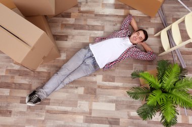 Yeni evinde hareketli bir genç adam. Üstten Görünüm.