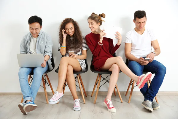 Grupo Personas Con Dispositivos Digitales Espera Una Entrevista Interiores —  Fotos de Stock