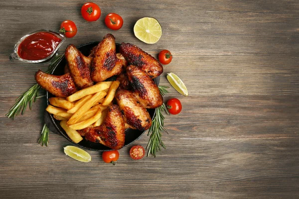 Asas de frango assadas com batatas fritas — Fotografia de Stock