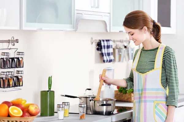 Jonge vrouw koken in keuken — Stockfoto