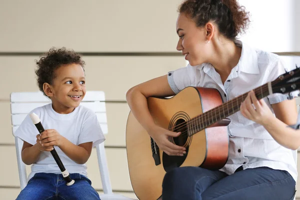 Girl and boy playing on music instruments Stock Photo