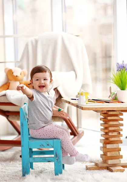 Little girl playing with toys in the room