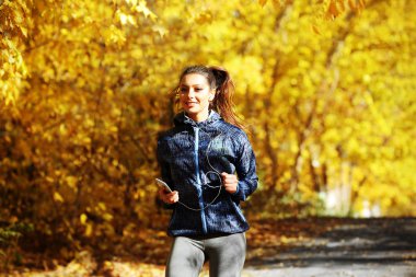 Sonbahar parkında koşan kadın 