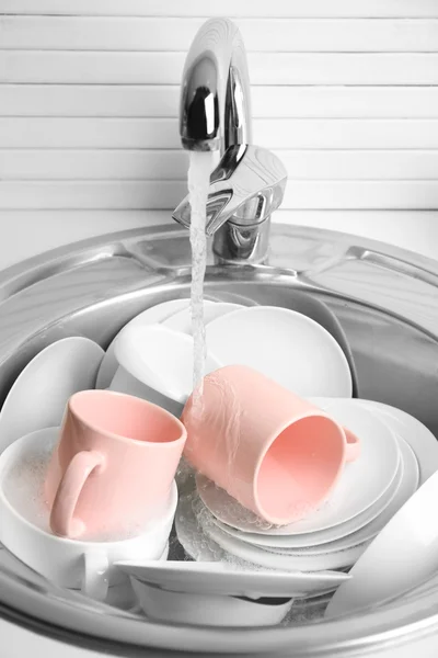 Pile of dishes in sink — Stock Photo, Image