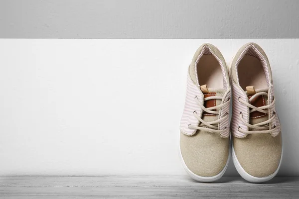 Sneakers per bambino sullo sfondo della parete — Foto Stock