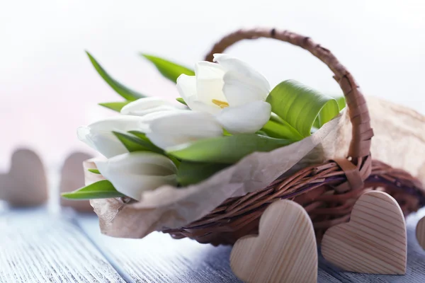 Witte tulpen in een rieten mand — Stockfoto