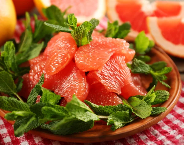 Juicy grapefruit pieces with fresh mint — Stock Photo, Image