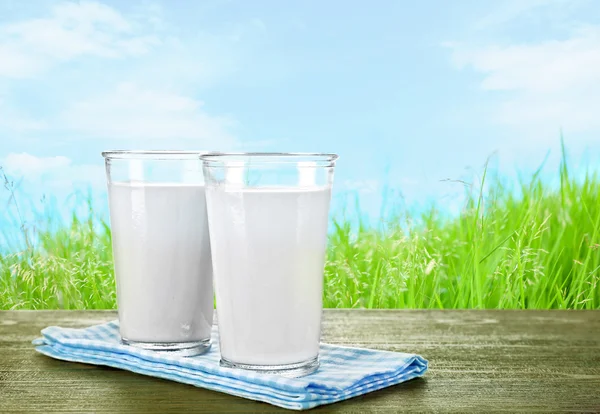 Vasos de leche sobre mesa de madera —  Fotos de Stock