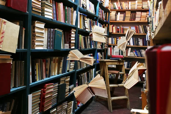 Livros voadores nas estantes da biblioteca — Fotografia de Stock