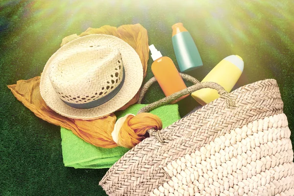 Wicker bag with scarf, hat and bottles — Stock Photo, Image