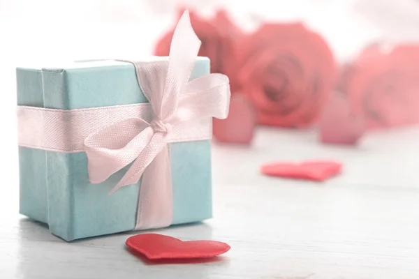 Presentask, rosa blommor och dekorativa hjärtan — Stockfoto