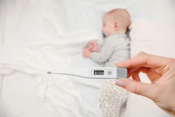 Liebendes Baby und Hand mit Thermometer — Stockfoto