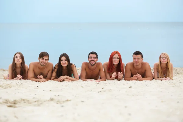 Jóvenes acostados en la playa —  Fotos de Stock