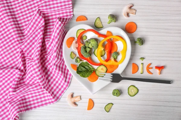 Verduras en un plato en forma de corazón — Foto de Stock