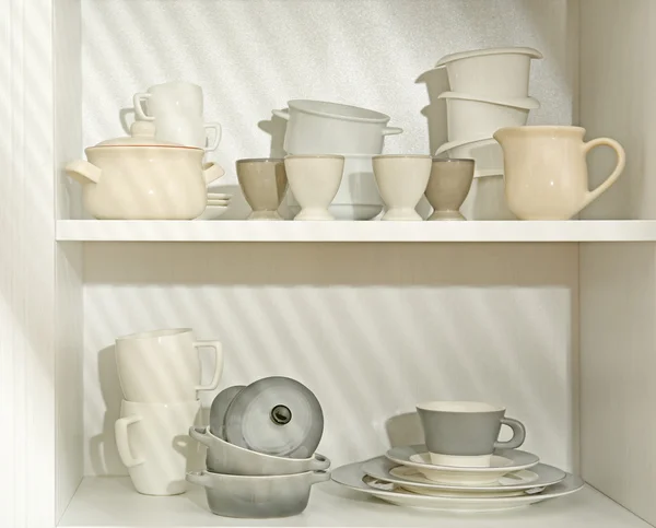 Dishes in cupboard in kitchen — Stock Photo, Image